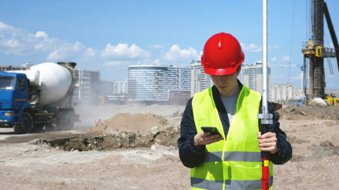 Land surveyor working on site – AllBIMclass Preliminary Works Node Land surveyor with total station representing the Preliminary Works node in the AllBIMclass BIM classification system